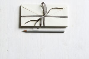 white envelope with a grey ribbon tied around it