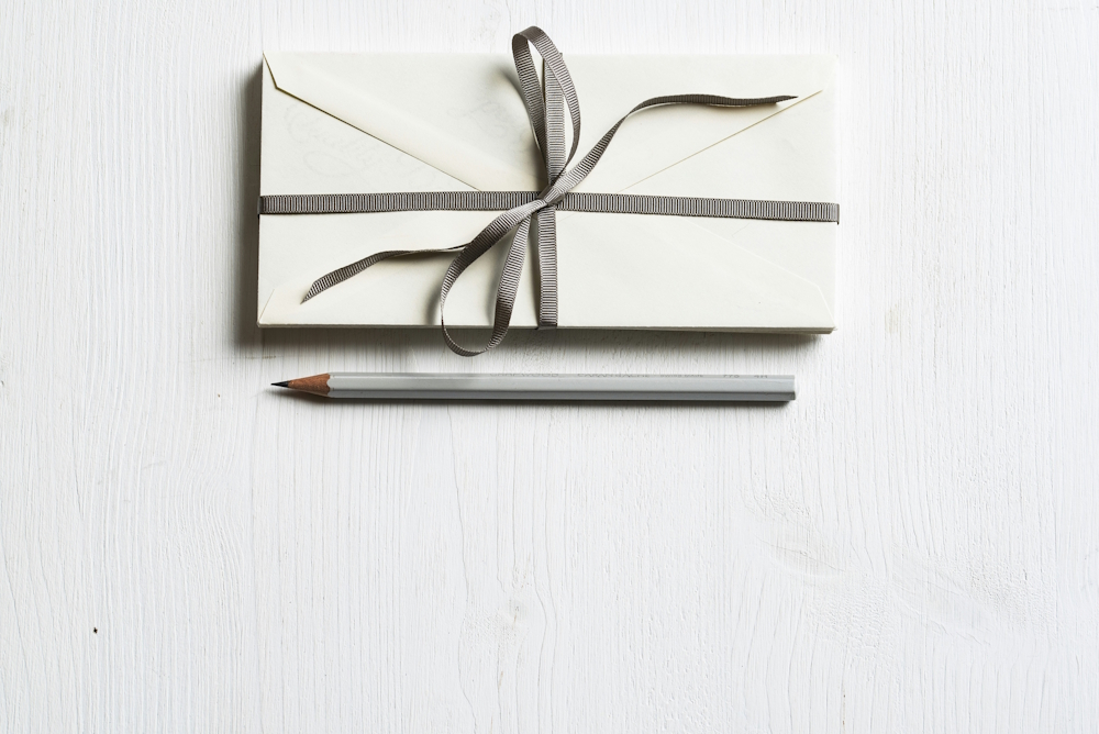 white envelope with a grey ribbon tied around it